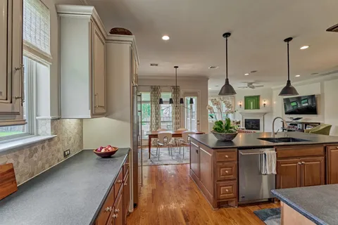 a kitchen with stainless steel appliances granite countertop a stove a sink and a wooden floors