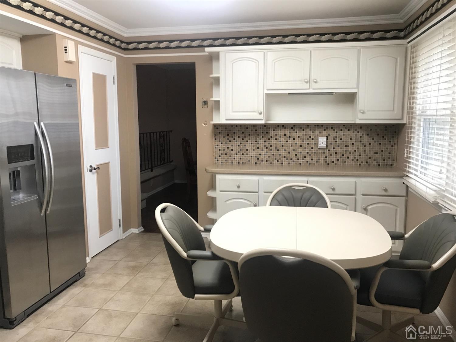 25 Roxy Avenue Edison, NJ 08820 - Photo 14 of 32 a kitchen with a table chairs and a refrigerator