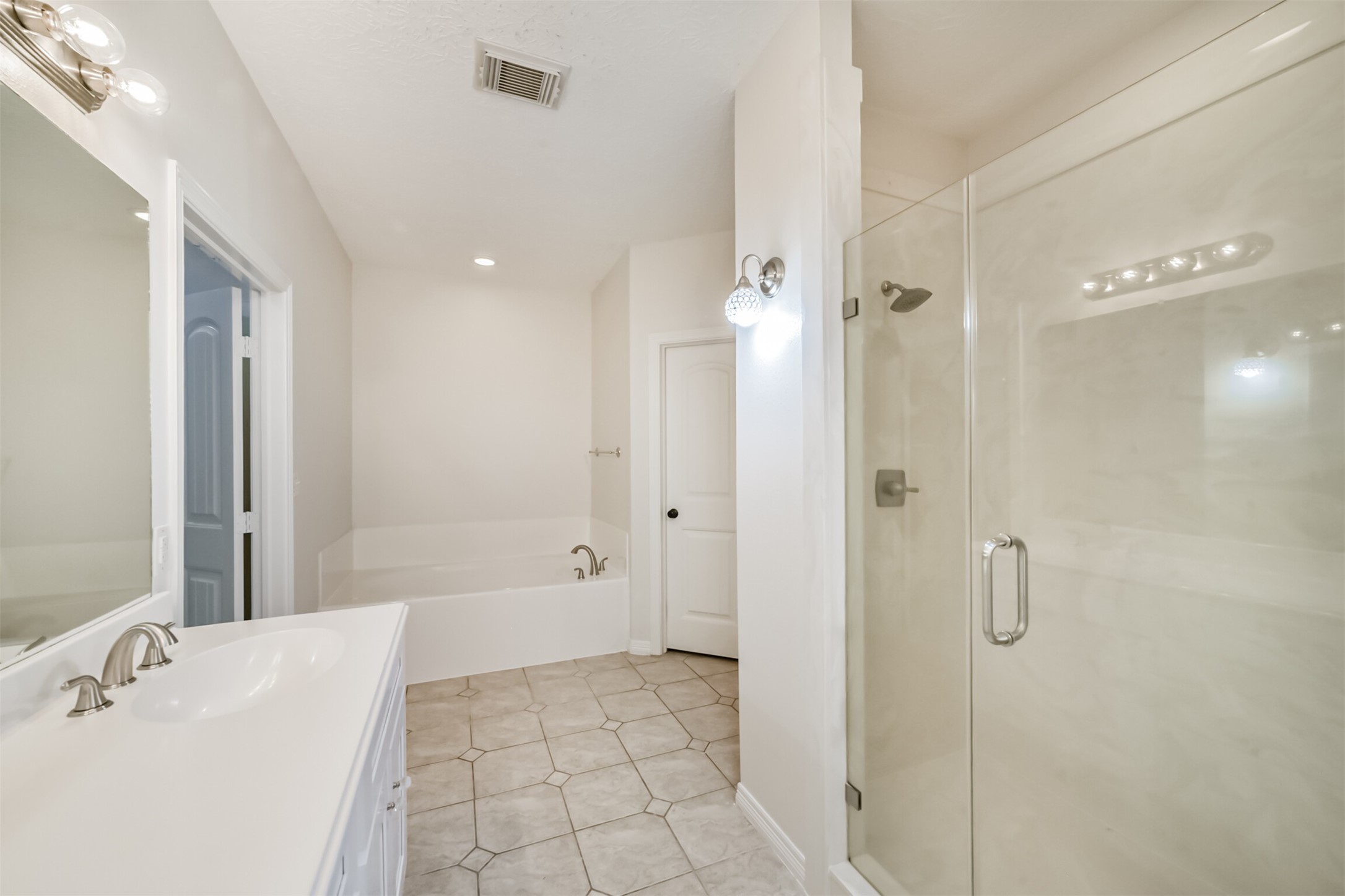 27322 Afton Way Huffman, TX 77336 - Photo 28 of 50 Luxurious primary bathroom includes dual vanities, updated lighting, and a spacious walk-in shower.