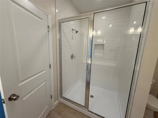 a bathroom with a shower and a glass door