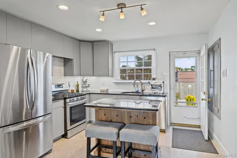 a kitchen with granite countertop a sink stove and refrigerator