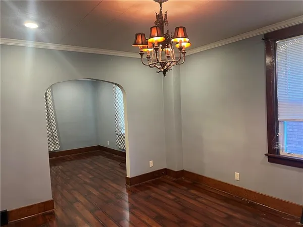 a view of a hallway with wooden floor and chandelier