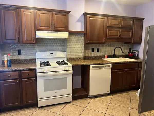 a kitchen with stainless steel appliances granite countertop a stove a sink and a microwave