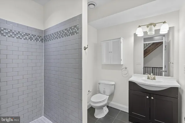 a bathroom with a sink mirror vanity and toilet