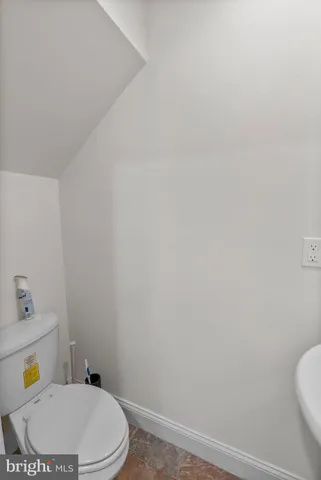 a white toilet sitting next to a bathroom sink and vanity