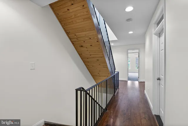 a view of a hallway with wooden floor and staircase