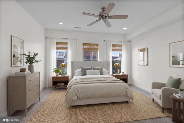 a spacious bedroom with a bed a couch and a dresser