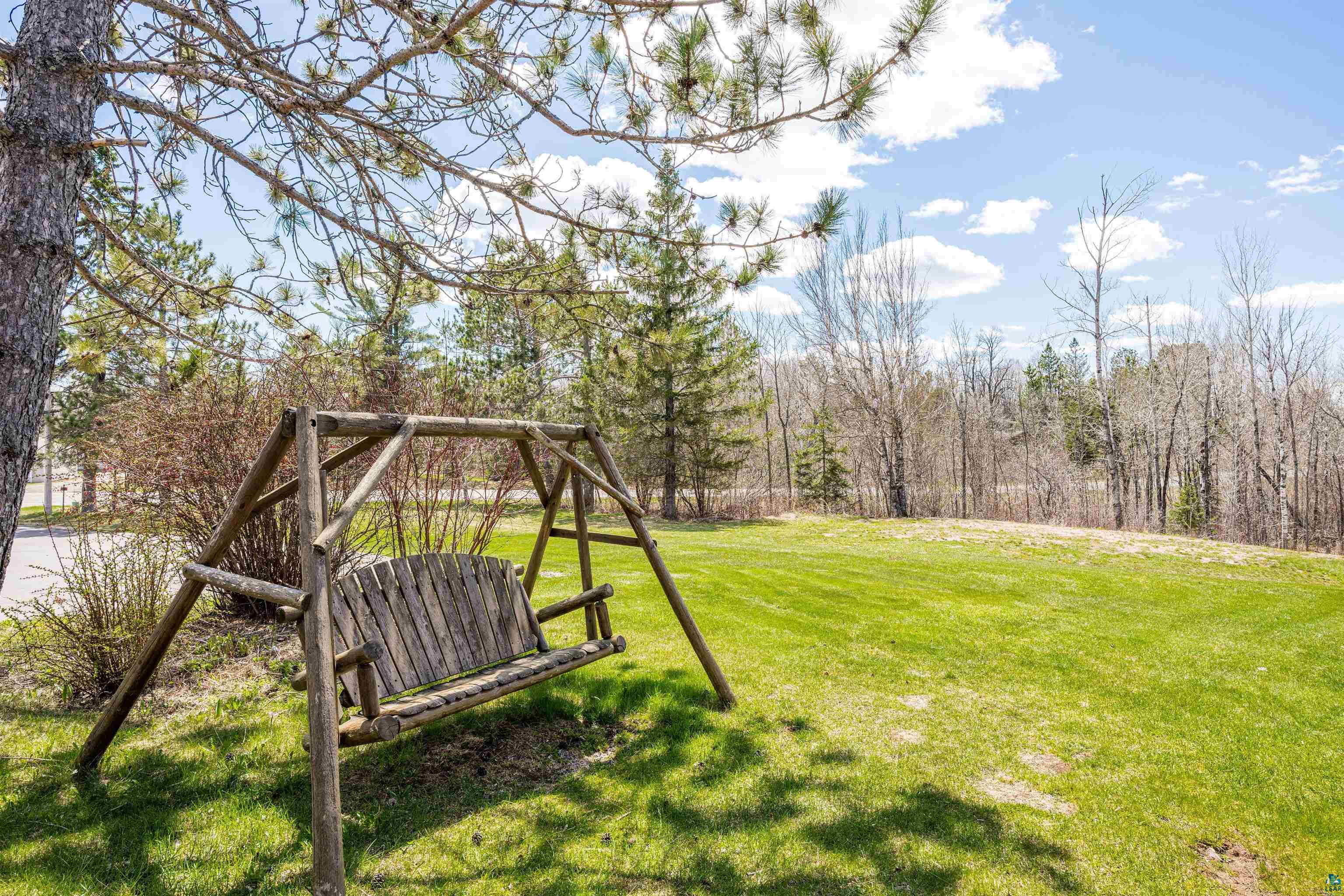3325 Strand Road Duluth, MN 55803 - Photo 9 of 25 Expansive front lawn & green space area featuring rustic log swing & room for outdoor recreation.
