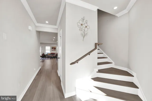 a view of a hallway with wooden floor and staircase