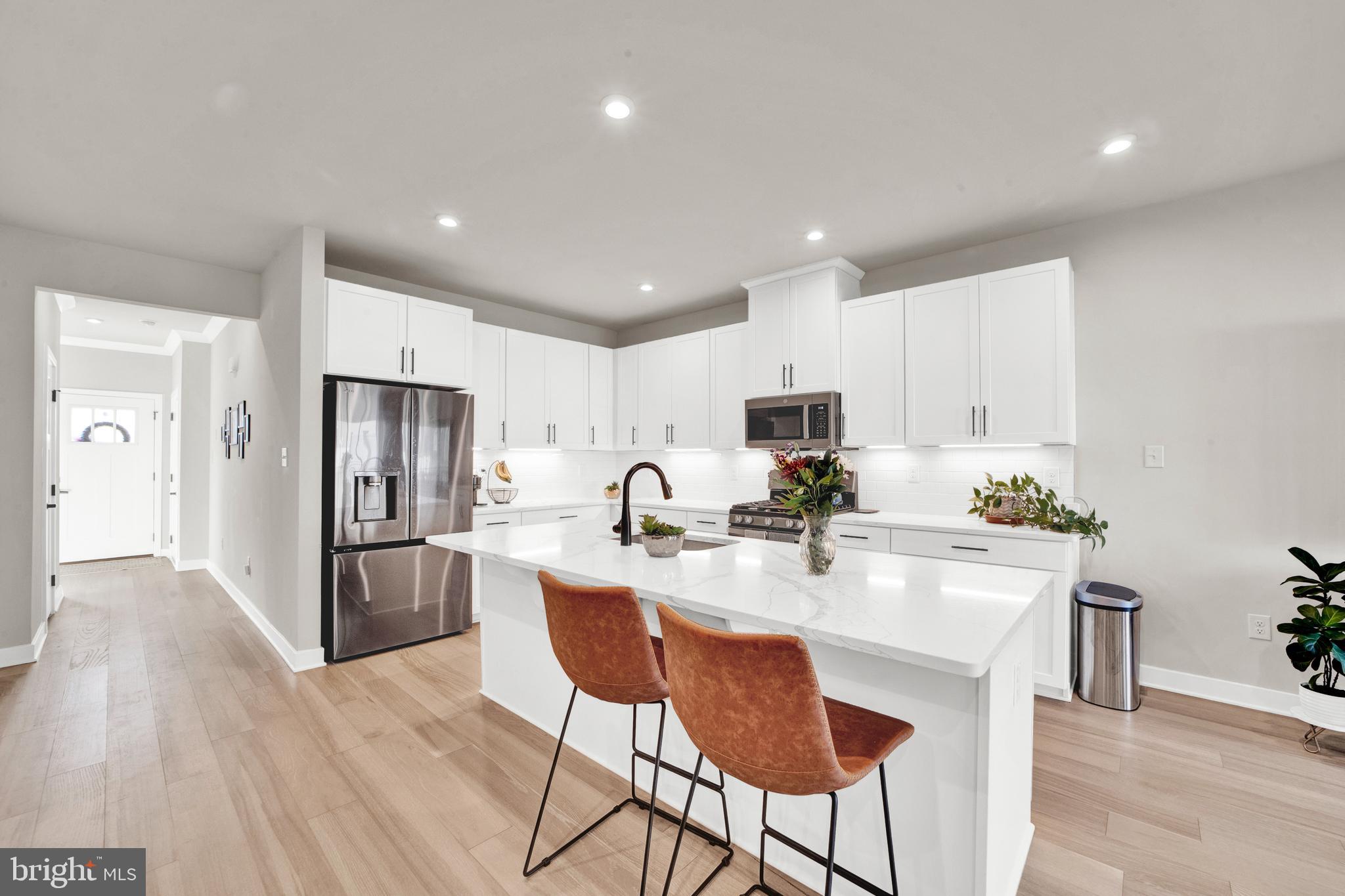 15 Pratt Lane Lawrence Township, NJ 08648 - Photo 9 of 31 a kitchen with stainless steel appliances a refrigerator a stove a sink a dining table and chairs