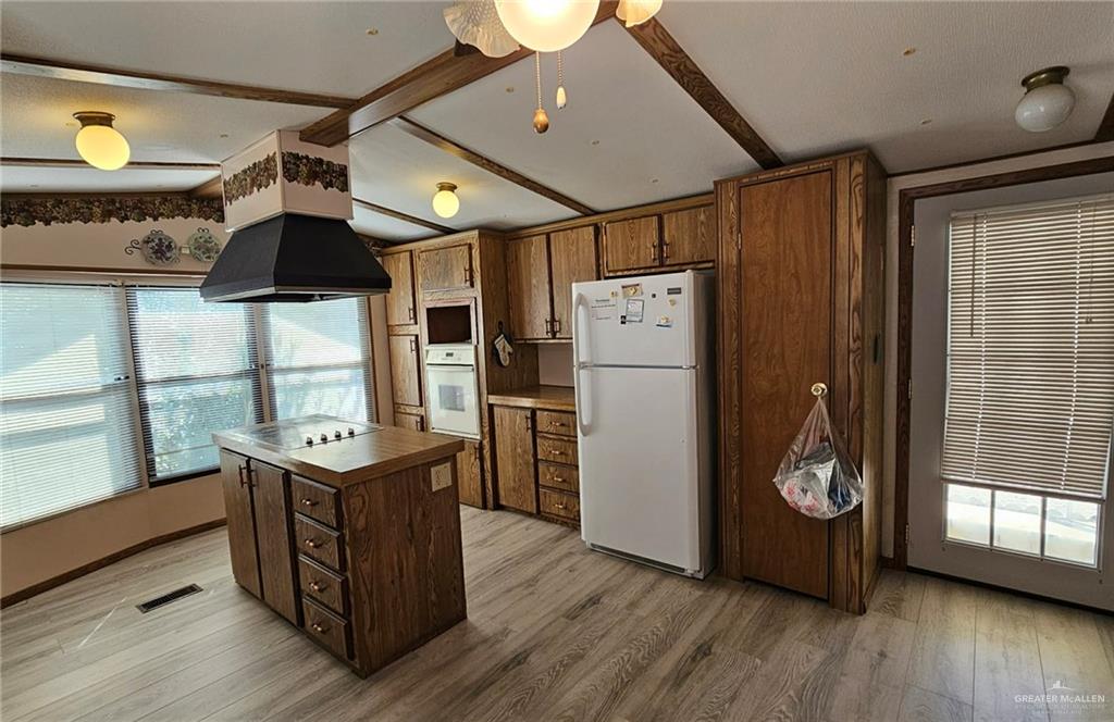1905 Johnson Street Mission, TX 78572 - Photo 8 of 22 a kitchen with stainless steel appliances granite countertop a refrigerator a sink dishwasher and wooden cabinets with wooden floor