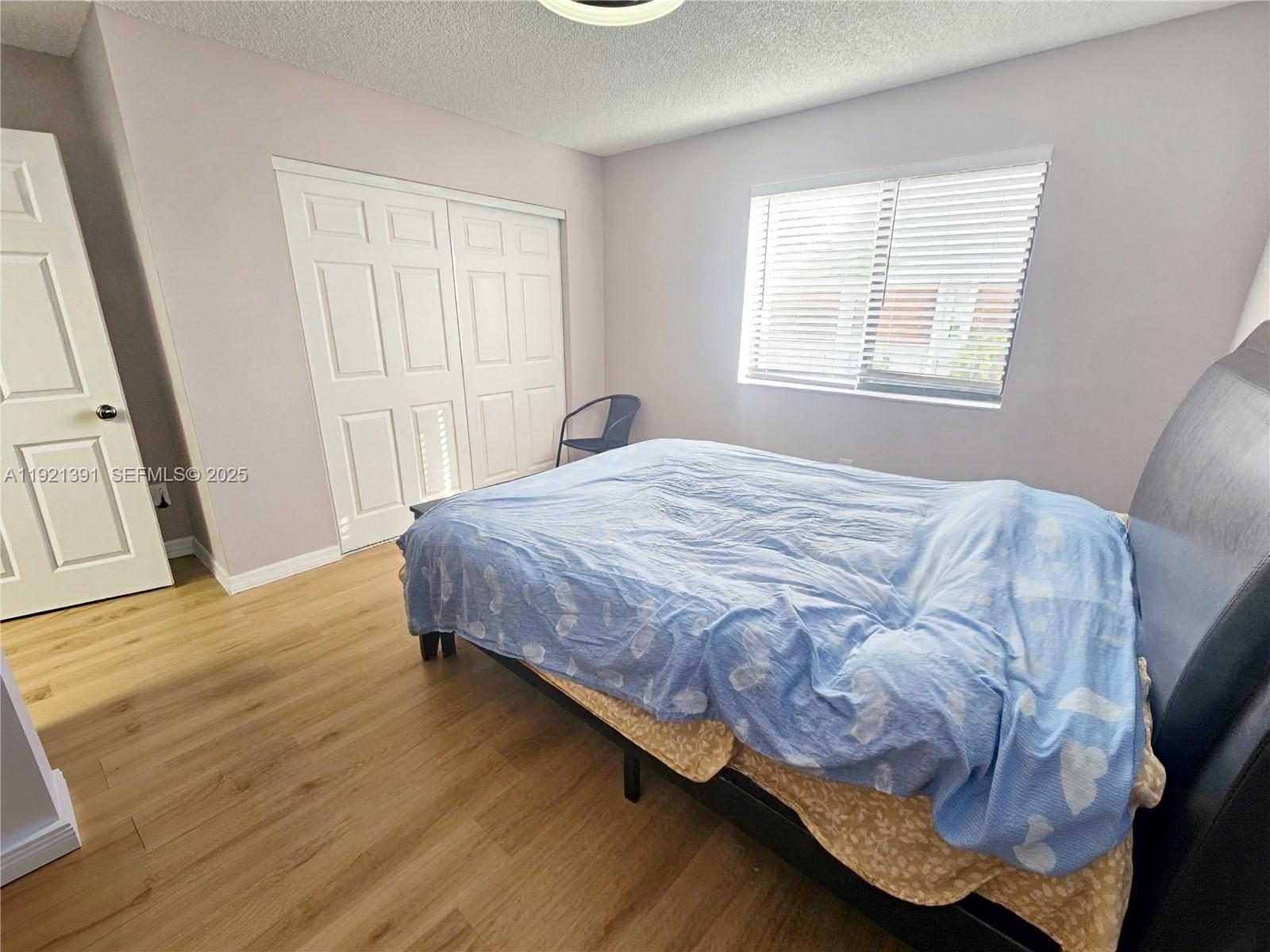 10700 Northwest 7th Street, Unit 5A Miami, FL 33172 - Photo 17 of 20 a bedroom with a bed and a window