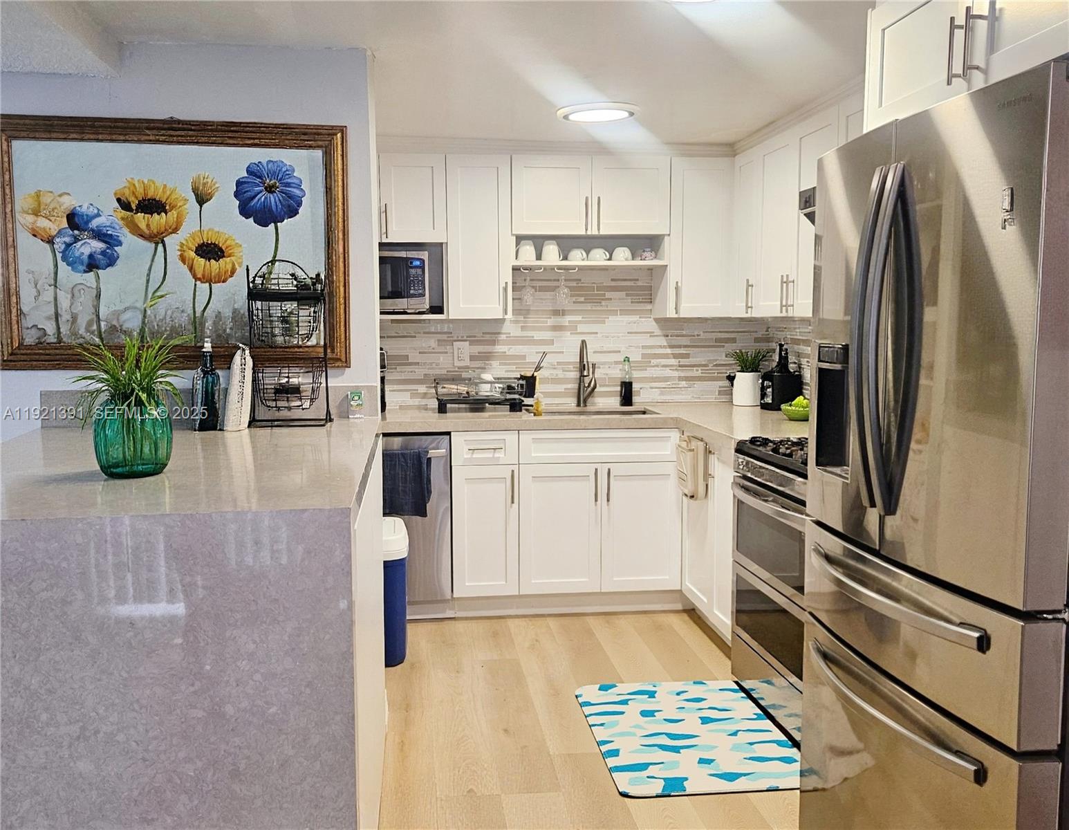 10700 Northwest 7th Street, Unit 5A Miami, FL 33172 - Photo 7 of 20 a kitchen with stainless steel appliances kitchen island granite countertop a refrigerator and a sink