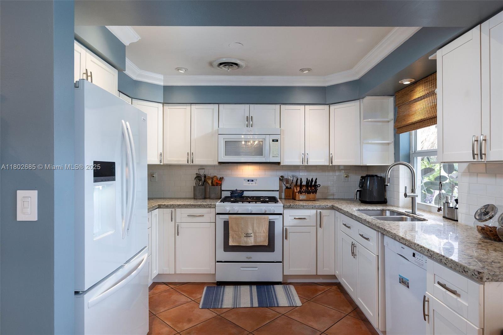 3192 Coolidge Street Hollywood, FL 33021 - Photo 12 of 34 a kitchen with stainless steel appliances granite countertop a stove a sink and a refrigerator