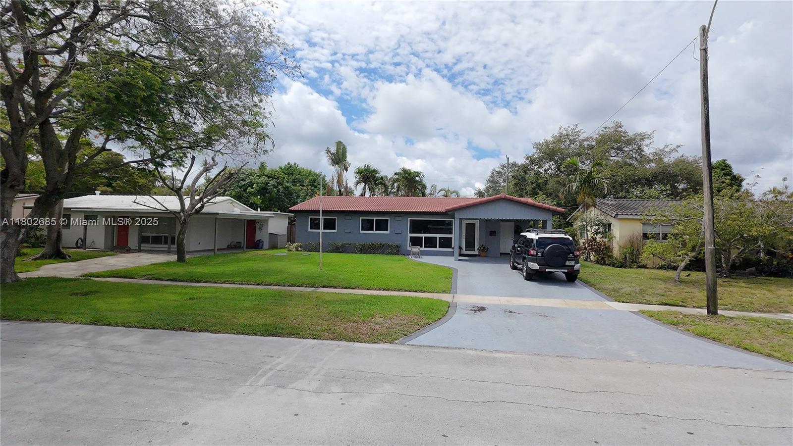 3192 Coolidge Street Hollywood, FL 33021 - Photo 28 of 34 a front view of a house with a garden and pathway