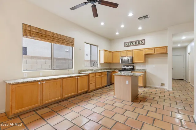 a large kitchen with kitchen island granite countertop a large counter top and appliances