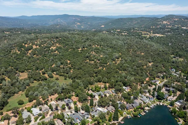 an aerial view of a houses with a lush green hillside