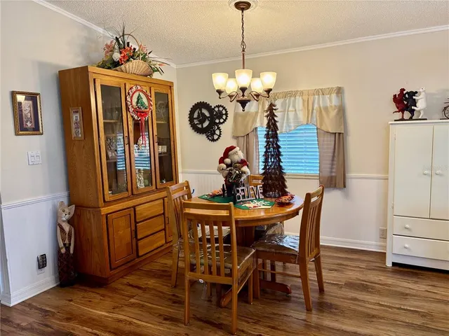 a view of a dining room with furniture wooden floor and chandelier