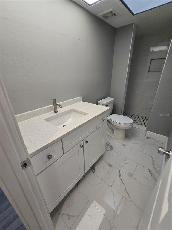 4836 Onyx Lane, Unit B New Port Richey, FL 34652 - Photo 11 of 13 a bathroom with a toilet sink and vanity