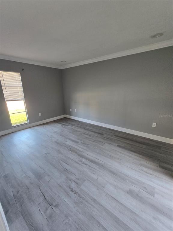 4836 Onyx Lane, Unit B New Port Richey, FL 34652 - Photo 8 of 13 a view of an empty room with wooden floor and a window