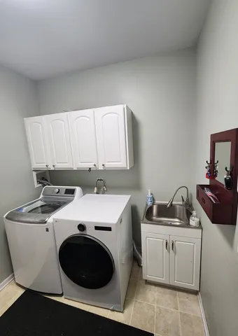 a large hall with stainless steel appliances wooden floor and chandelier