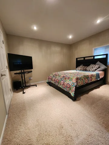 a view of a patio with couches and a table and chairs with wooden floor and fence
