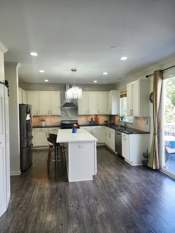a kitchen with a sink a refrigerator a counter top space and stainless steel appliances