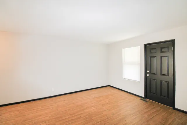 an empty room with wooden floor and closet