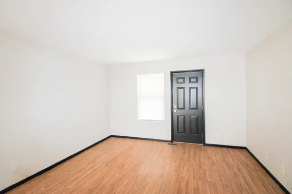 a view of an empty room with wooden floor