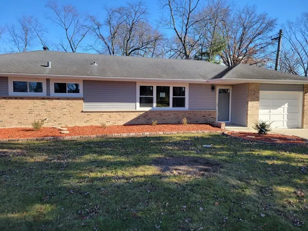 a front view of a house with a yard and outdoor seating