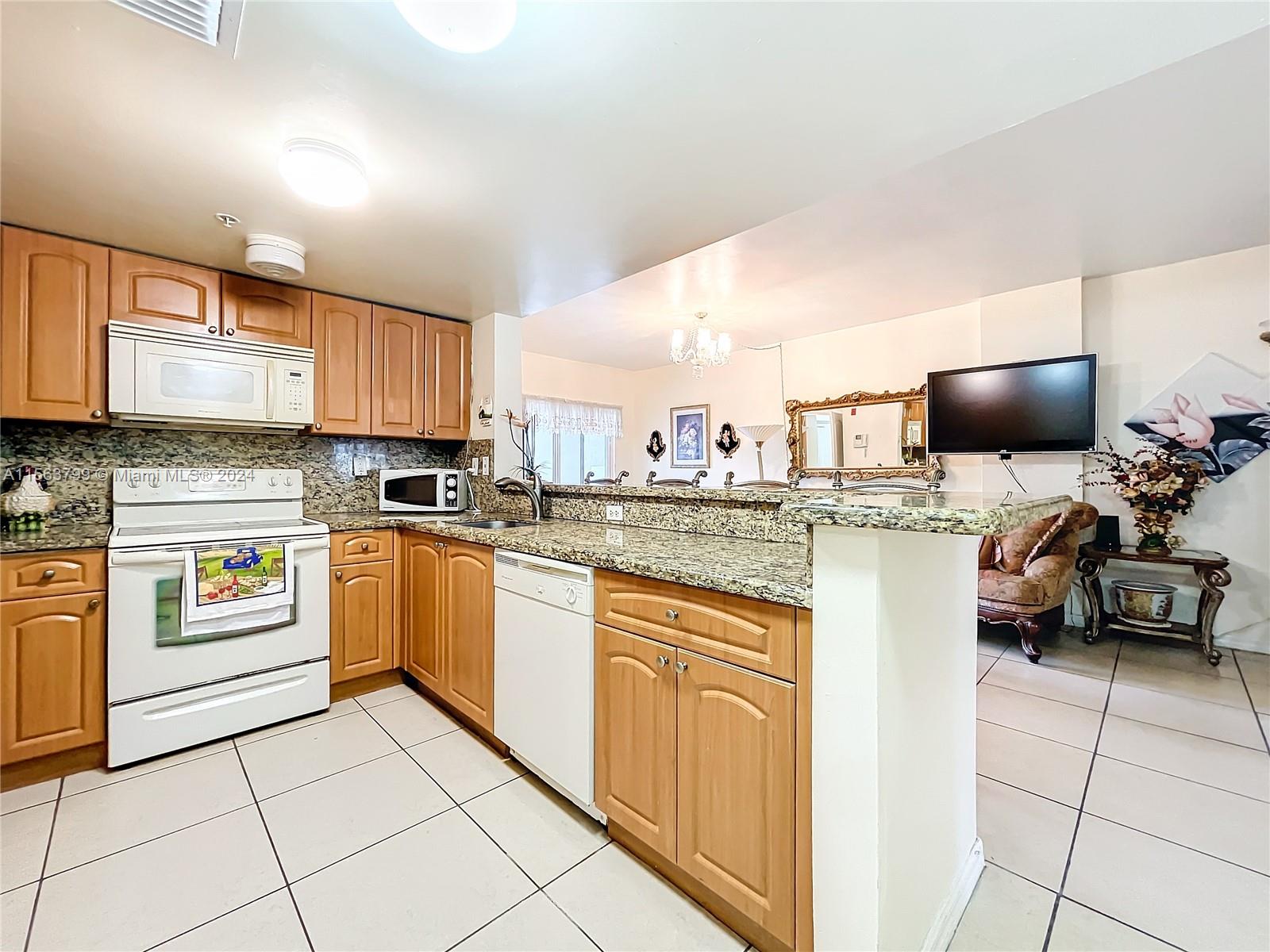 120 South Douglas Road, Unit 302 Miami, FL 33134 - Photo 11 of 28 a kitchen with a sink a stove and cabinets