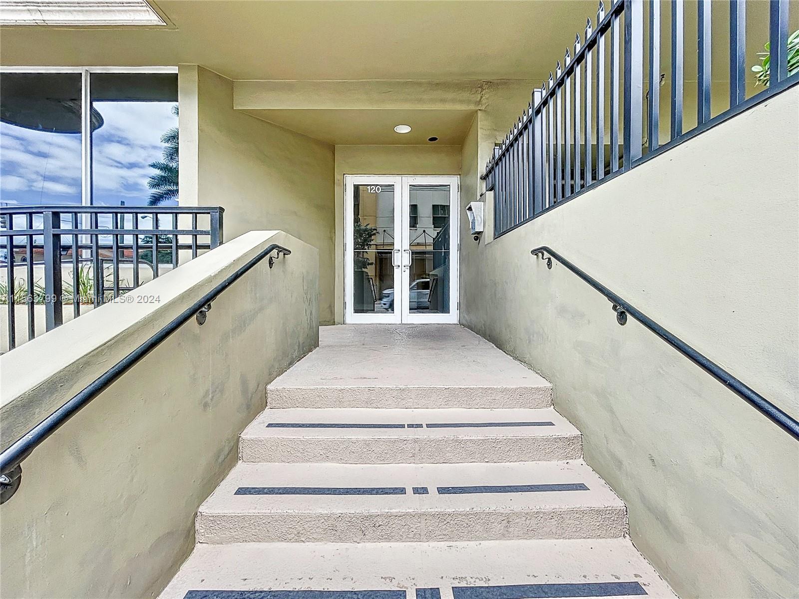 120 South Douglas Road, Unit 302 Miami, FL 33134 - Photo 4 of 28 a view of staircase with lots of frames on wall and a window