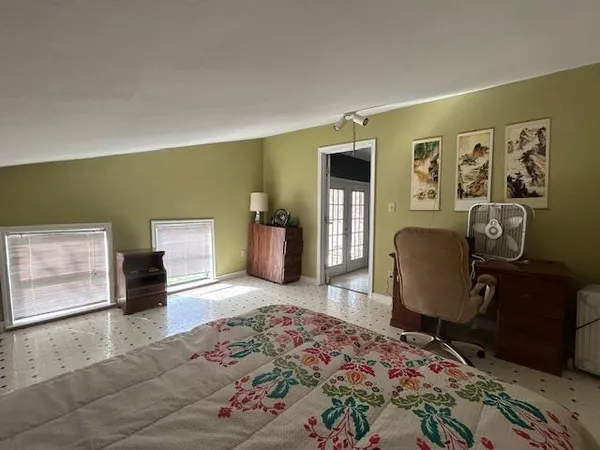 a bedroom with a bed dresser and a window