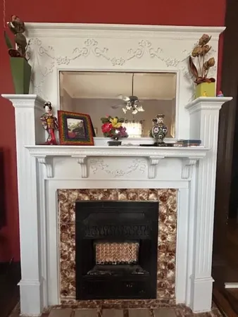 a fireplace with a vase of flowers on it