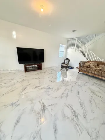 a glass room with furniture and a flat screen tv