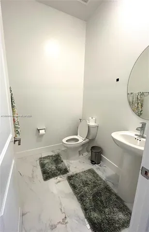 a bathroom with a toilet a sink and a mirror