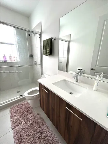 a bathroom with a sink toilet a mirror and shower