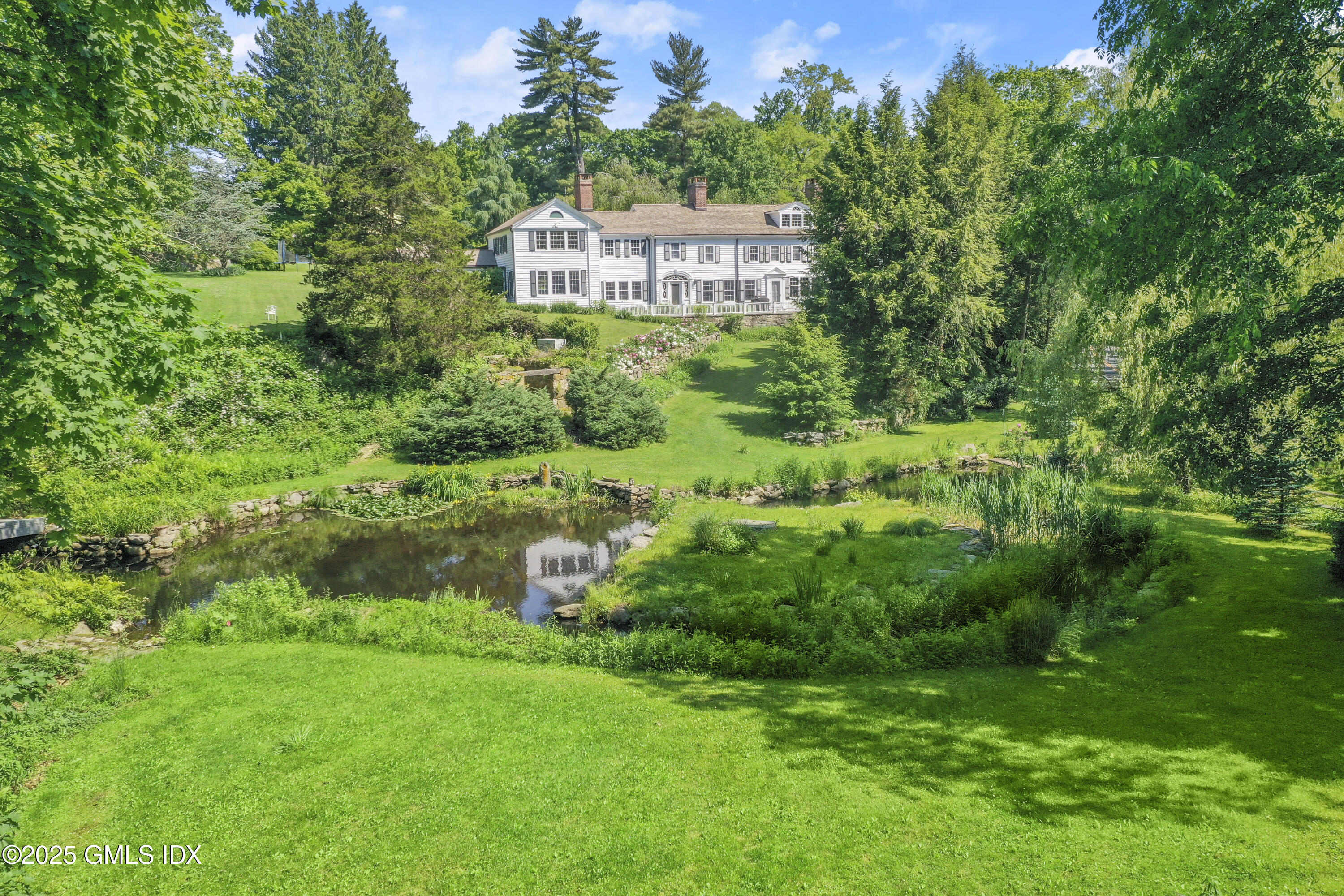 29 Taconic Road Greenwich, CT 06830 - Photo 1 of 1 a view of a garden with a building in the background