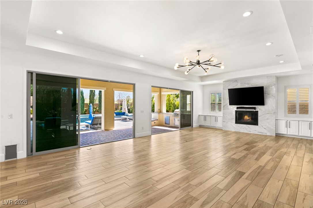 4039 Villa Rafael Drive Las Vegas, NV 89141 - Photo 15 of 45 Unfurnished living room with a tray ceiling, a chandelier, plenty of natural light, and recessed lighting
