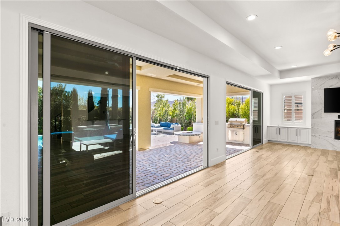 4039 Villa Rafael Drive Las Vegas, NV 89141 - Photo 16 of 45 Doorway featuring wood finished floors, recessed lighting, a premium fireplace, and a raised ceiling