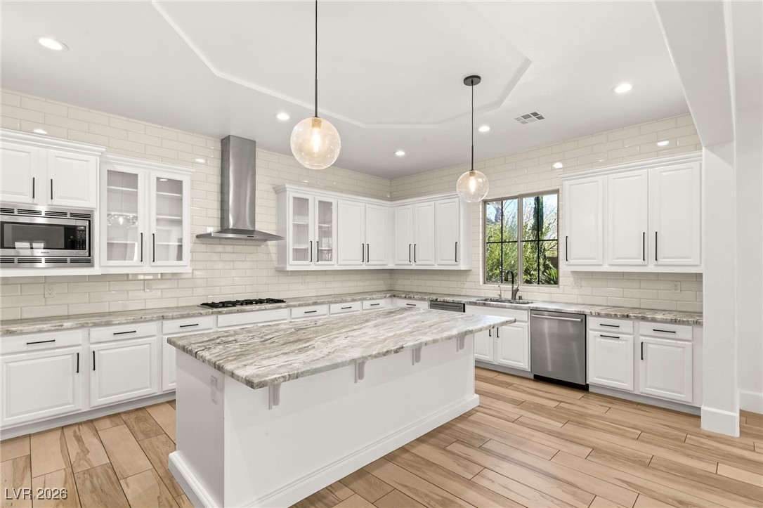4039 Villa Rafael Drive Las Vegas, NV 89141 - Photo 20 of 45 Kitchen with tasteful backsplash, recessed lighting, white cabinetry, light stone countertops, and a breakfast bar