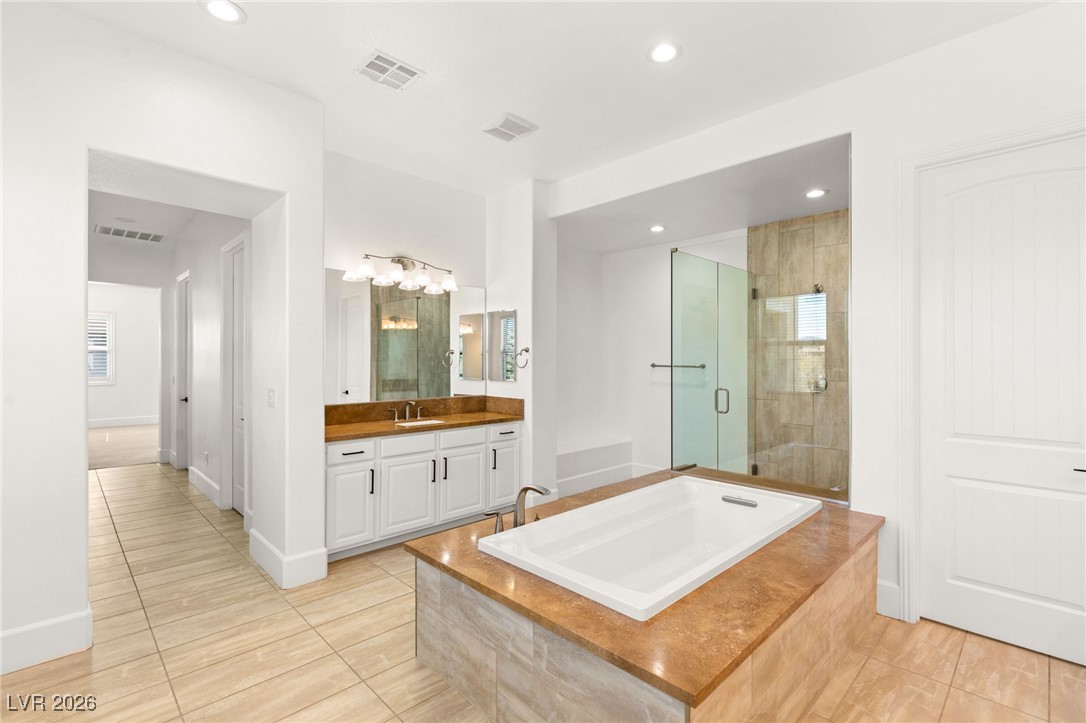 4039 Villa Rafael Drive Las Vegas, NV 89141 - Photo 26 of 45 Bathroom with recessed lighting, a bath, vanity, light tile patterned floors, and a shower stall