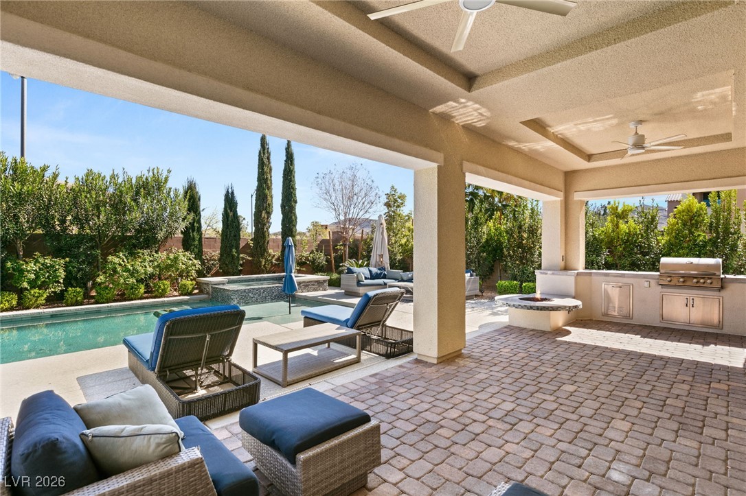 4039 Villa Rafael Drive Las Vegas, NV 89141 - Photo 38 of 45 Fenced backyard featuring an outdoor living space with a fire pit, a patio area, exterior kitchen, a ceiling fan, and a pool with connected hot tub