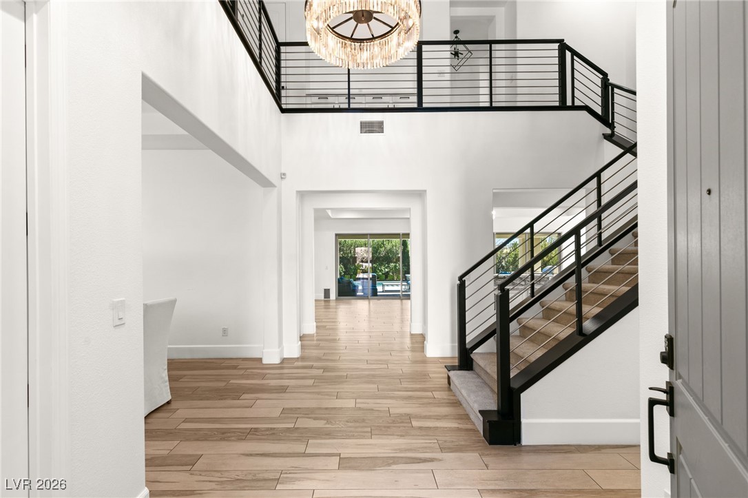4039 Villa Rafael Drive Las Vegas, NV 89141 - Photo 5 of 45 Foyer featuring a towering ceiling, light wood finished floors, a chandelier, and stairway