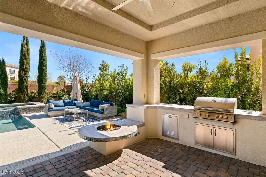 4039 Villa Rafael Drive Las Vegas, NV 89141 - Photo 8 of 45 View of patio featuring a fire pit, a ceiling fan, exterior kitchen, and a pool with connected hot tub