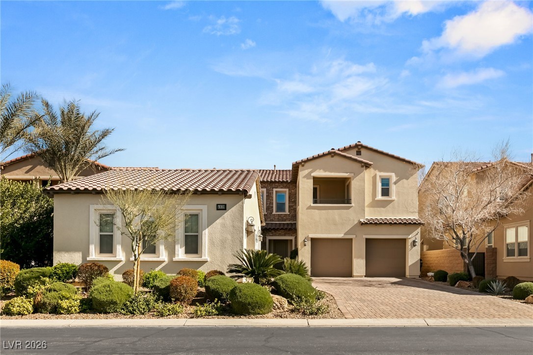 4039 Villa Rafael Drive Las Vegas, NV 89141 - Photo 10 of 45 Mediterranean / spanish-style house with stucco siding, an attached garage, decorative driveway, and a tile roof