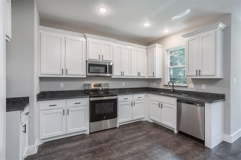326 West Day Street Denison, TX 75020 - Photo 13 of 27 a kitchen with granite countertop white cabinets white stainless steel appliances with a sink and dishwasher