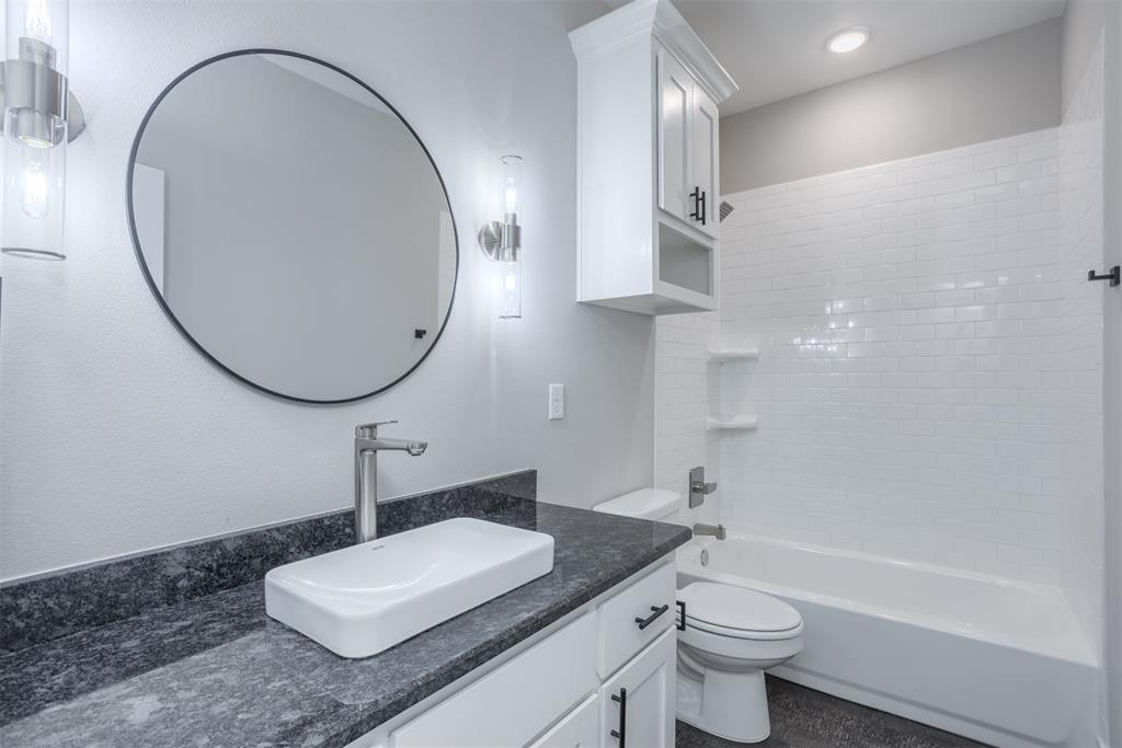 326 West Day Street Denison, TX 75020 - Photo 26 of 27 a bathroom with a sink a toilet and a mirror