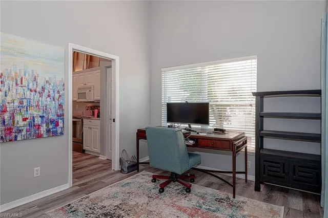 a view of a workspace with furniture and a window