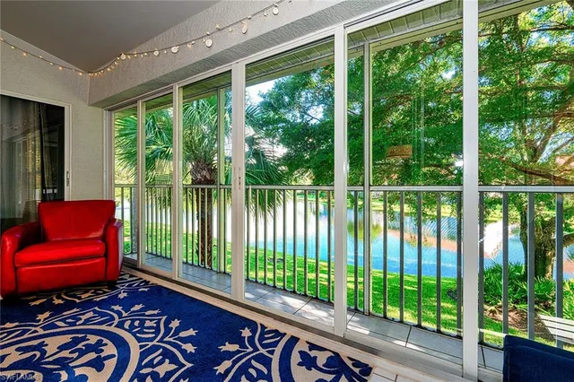 a living room with large windows and furniture